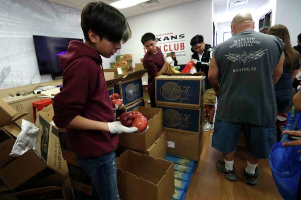 Miguel Mendoza, 14, hands out food at the food pantry which runs out of the Heights Boys and Girls Club, every other Thursday, in Houston,Thursday, March 12, 2020. The teens volunteer to hand out food. While local health officials are still recommending that schools remain open amid coronavirus fears, the looming threat of canceling K-12 classes means parents are making child care plans and local organizations are making preliminary plans to accommodate kids. Experts said the region’s experience with recent natural disasters and the gradual ramp-up of the coronavirus gives time for agencies to make preparations. Still, parents are concerned about student health and school cancellations could be difficult for working parents without easy access to child care.