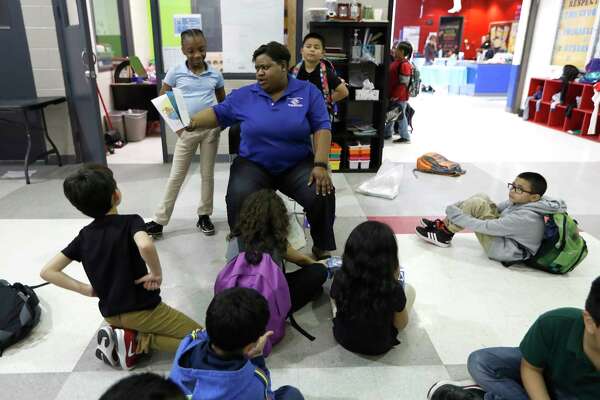 Myra Coleman, lead staffer reads to children at the Heights Boys and Girls Club, in Houston,Thursday, March 12, 2020. While local health officials are still recommending that schools remain open amid coronavirus fears, the looming threat of canceling K-12 classes means parents are making child care plans and local organizations are making preliminary plans to accommodate kids. Experts said the region’s experience with recent natural disasters and the gradual ramp-up of the coronavirus gives time for agencies to make preparations. Still, parents are concerned about student health and school cancellations could be difficult for working parents without easy access to child care.