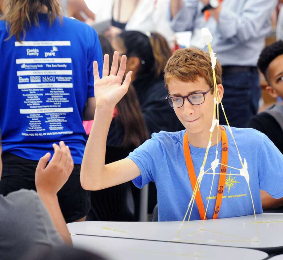 studies program high-fives a fellow student after their team wo
