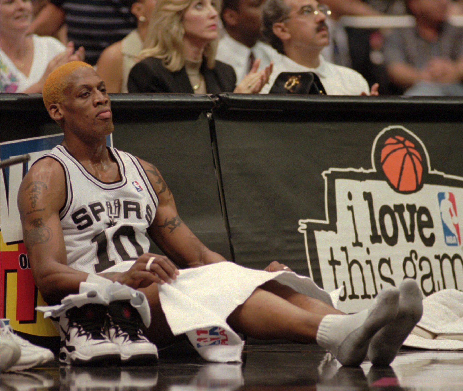 Dennis Rodman sitting on the sidelines waiting to check into an NBA game.