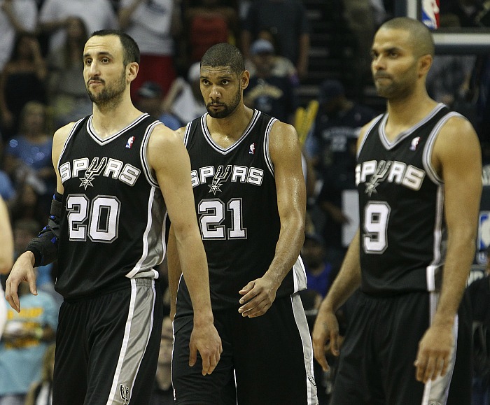 Tim Duncan, Tony Parker and Manu Ginobili walking together in the same direction during an NBA game.