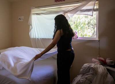 Marie makes the bed in her room at her Marin County home. Her first stay in juvenile hall was 29 days, for misdemeanor resisting arrest.