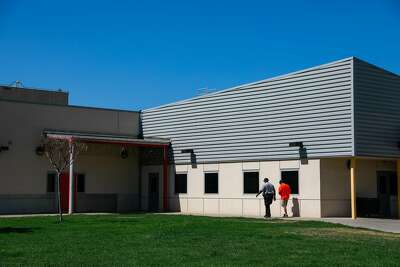 An incarcerated youth is escorted by a probation officer as he walks across the grounds at the Fresno County juvenile hall in Fresno.