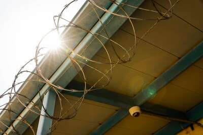 Security at the Fresno County juvenile hall includes barbed wire and a surveillance camera.