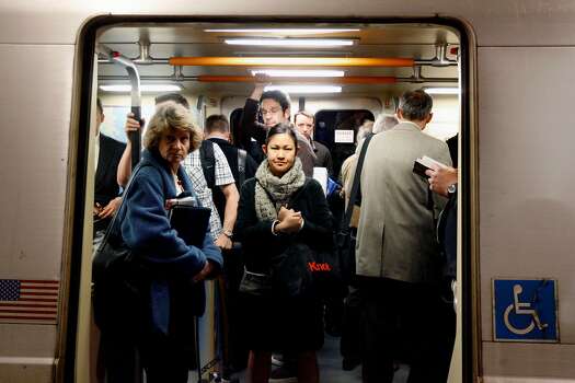Commuters at Embarcadero Station crowd into a BART car in San Francisco, California.