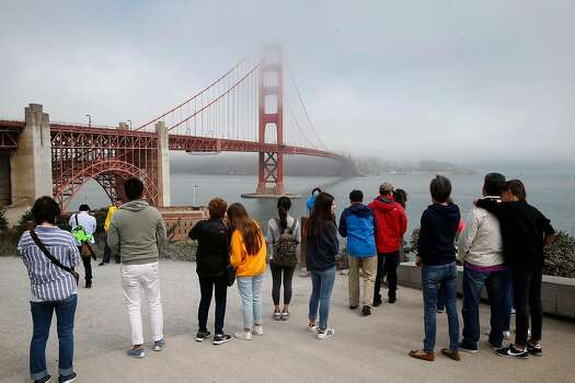 A crowd of visitors snap pictures of the Golden Gate Bridge in San Francisco, California, on Friday, Aug. 3, 2018.