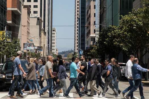 A large group of San Francisco workers, residents and tourists cross Mission Street at New Montgomery in the South of Market district of San Francisco, California, on Friday, July 20, 2018.