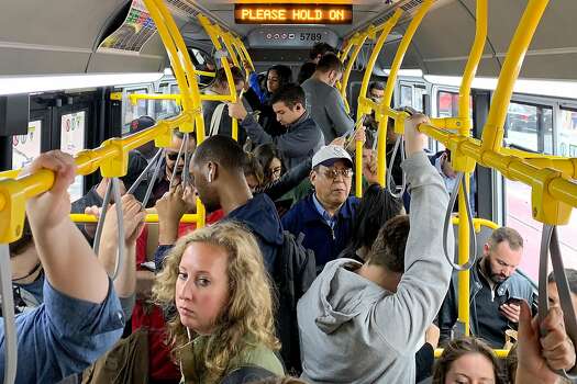 Riders pack onto a very crowded Muni bus as it makes its way down Market Street in San Francisco, California, on Tuesday, July 18, 2019.