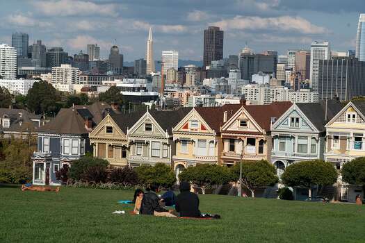 Just a few people in Alamo Square next to the Painted Ladies, Victorian and Edwardian houses and buildings, on March 19, 2020 in San Francisco, California.