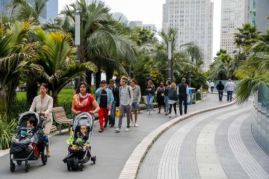 Just under 20 people walk along the pathway of Salesforce Park on Monday, July 1, 2019, in San Francisco, California.