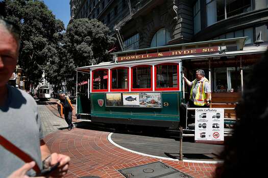 Workers rotate a cable car at the Powell Street cable car turnaround on Friday, August 30, 2019 in San Francisco, California.