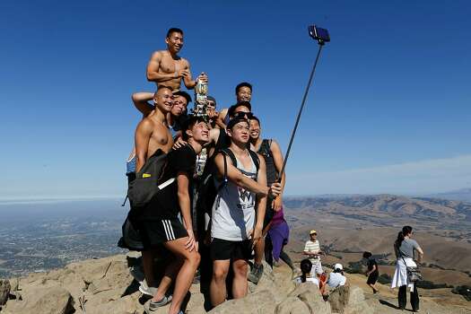 A large group of friends gather for a selfie at the summit post atop Mission Peak above Fremont , California, on Saturday Sept. 13, 2014.