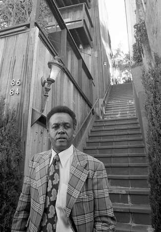 Portrait of Rotea Gilford at a crime scene, wearing a plaid jacket and paisley tie.