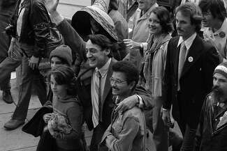 Harvey Milk waves to supporters at his swearing-in ceremony.