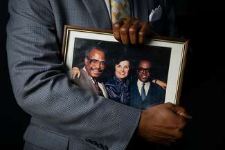 Marcus Sanders holds a framed photograph of his father, Earl Sanders, with Dianne Feinstein and Rotea Gilford.