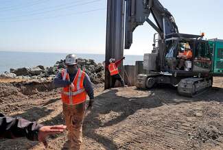 Installing steel plates that are part of the rebuilt, taller levee along Beach Park Boulevard in Foster City.