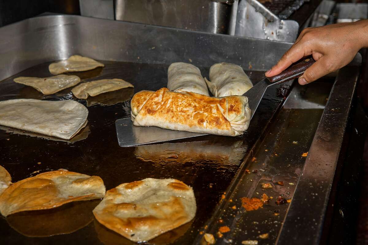 A crisped burrito gets flipped on a flat-top