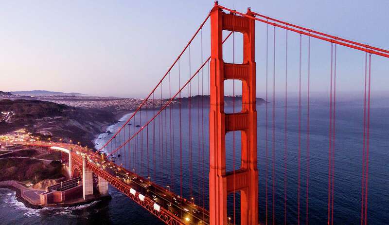 The Golden Gate Bridge at daybreak in September. A map shows the location of the bridge.