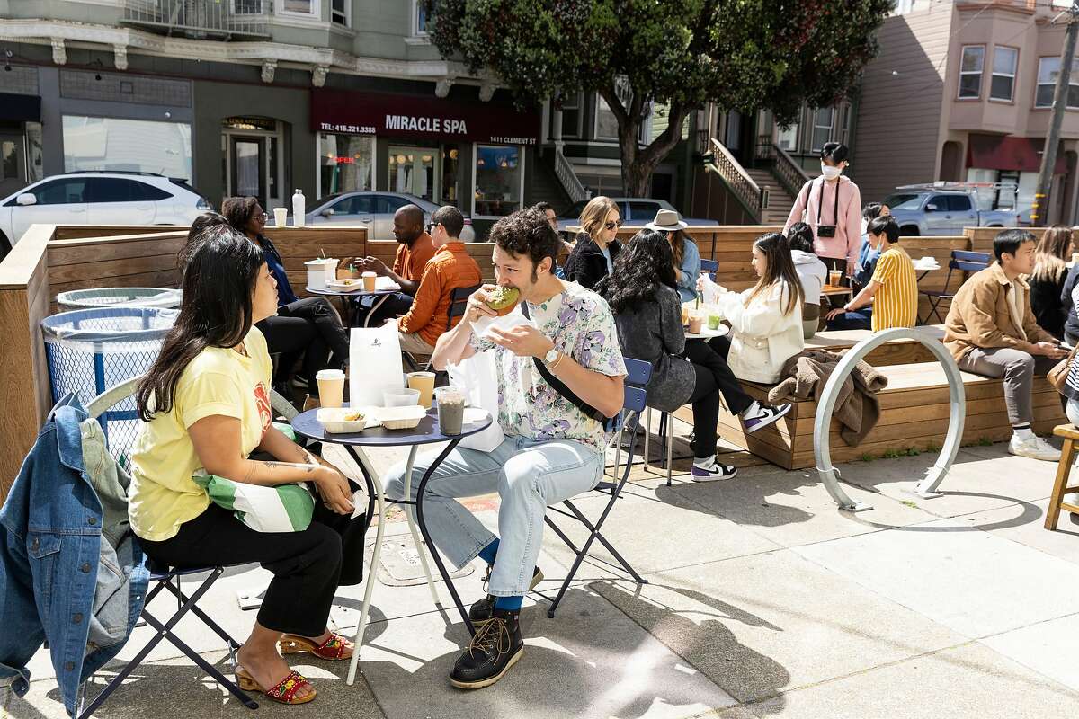 People eating on the sidewlk and parklet outside Breadbelly