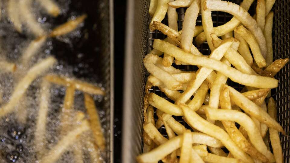 Close-up of fries being cooked in a deep fryer.