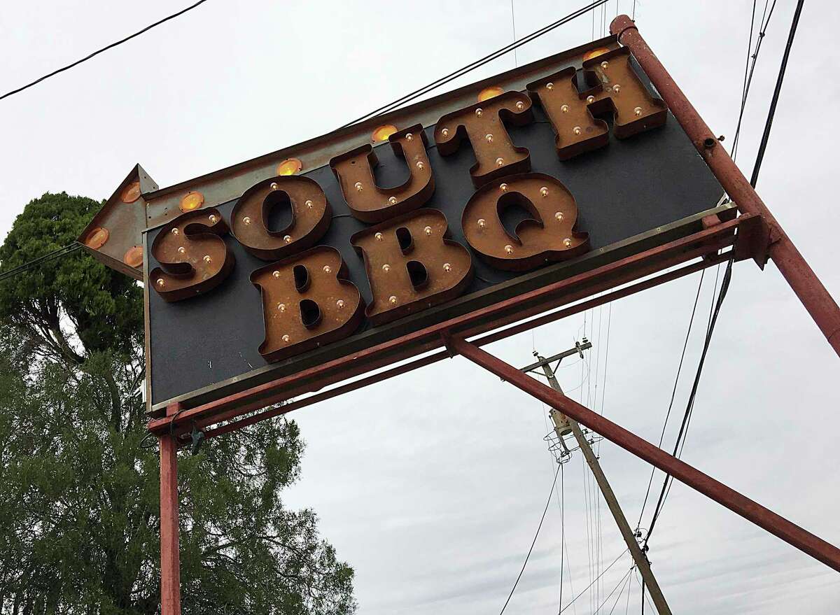A new sign by the roadside points toward South BBQ & Kitchen, a barbecue restaurant on Mission Road.