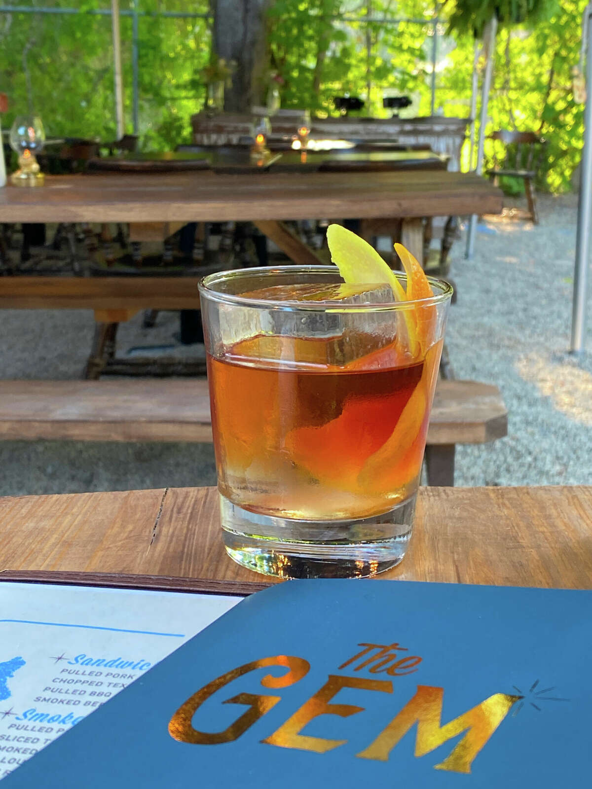 An Old-Fashioned cocktail in the backyard dining area at The Gem.