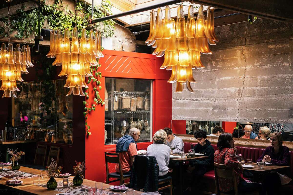 Chandeliers hanging over a red-painted dining room.