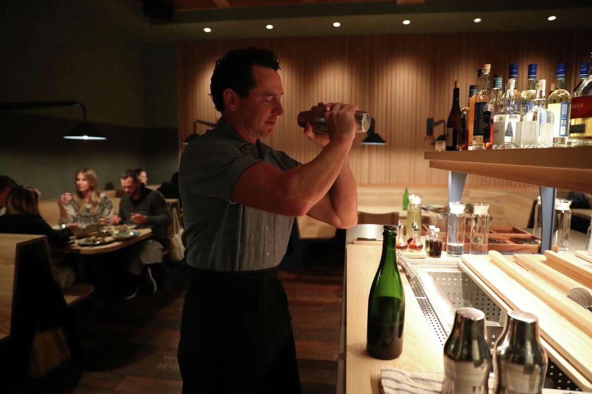 A bartender makes a drink at Bar Agricole.