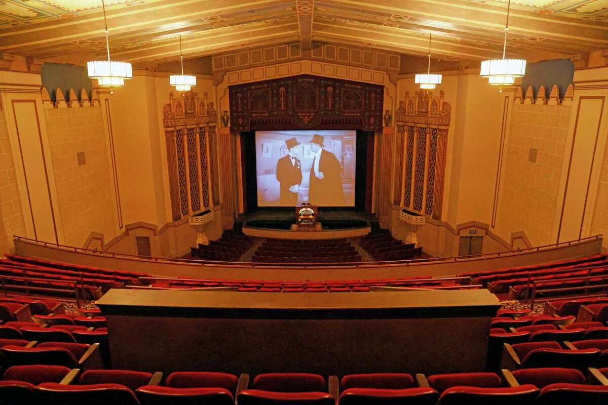 The inside of the Stanford Theatre with a Laurel and Hardy movie on the screen, as seen from the balcony.