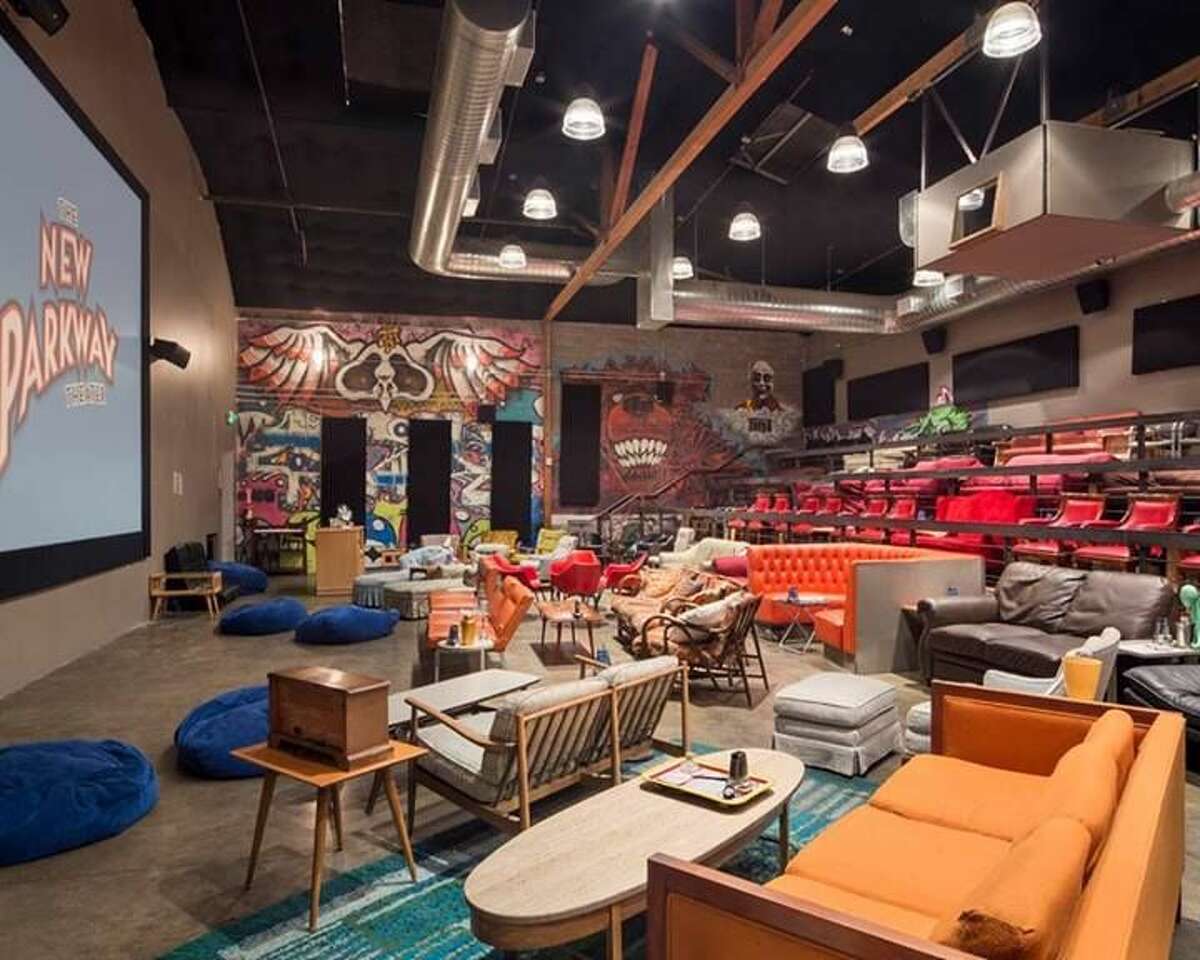 The inside of a New Parkway theater shows bean bag chairs, couches and a colorful mural in the background