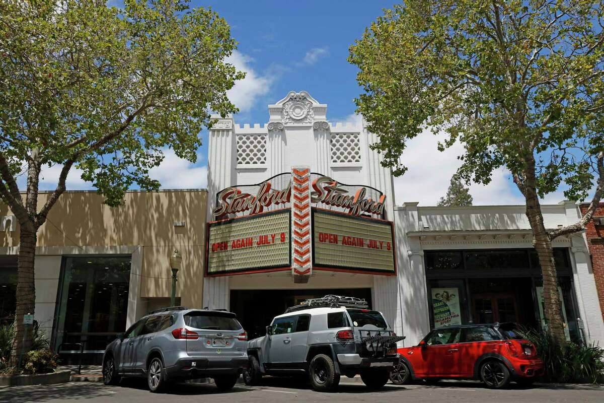 The marquee of the Stanford Theatre in the daytime with cars parked in front.
