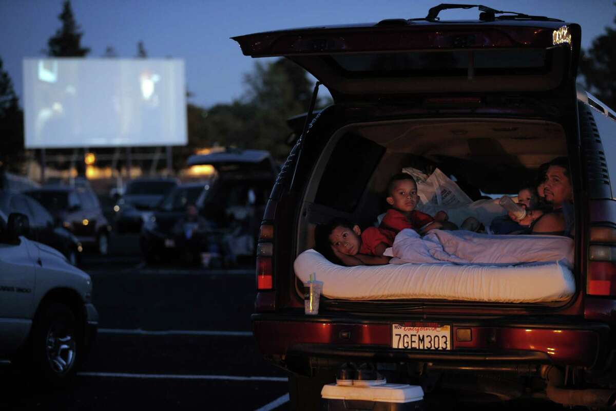 Children are packed in the back of an SUV at the Solano Drive-In watching a Pixar movie.