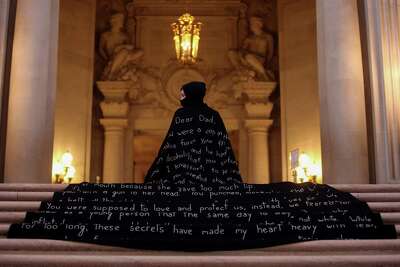 Patricia Diart wears a black cape with an embroidered letter to her policeman father at San Francisco's City Hall.