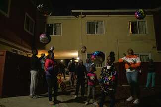 A group of Jackie Mason’s family and friends release balloons at night.