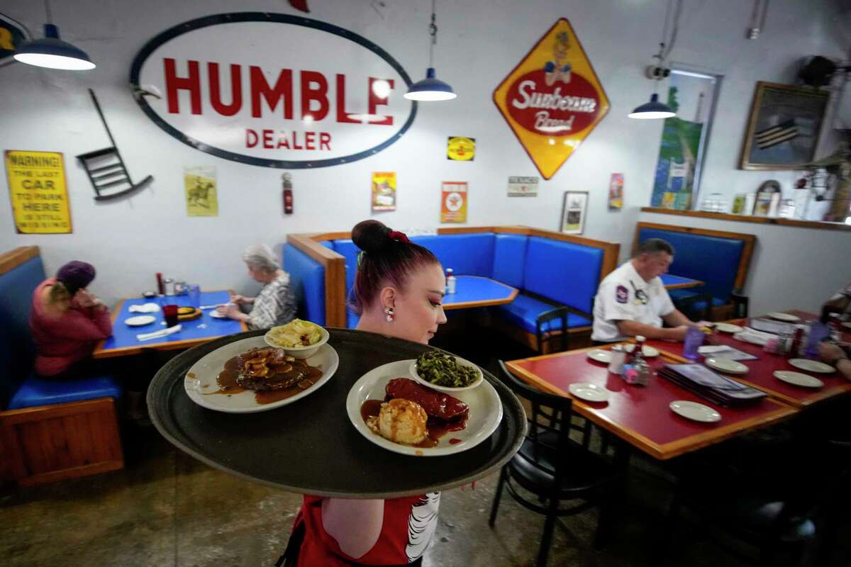 Server Nicole Price brings out plates of food for customers during the lunch service at Humble City Cafe on Thursday, Dec. 8, 2022 in Humble.