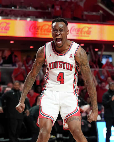 A basketball player screams in elation and flexes his arms.