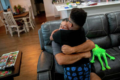 Rey Gonzales hugging his son Breydan before sending him to bed the night before his first day of school.
