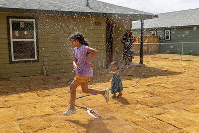 Sofia Vallejo jumping through the sprinkler with her niece Jasmine Vallejo.