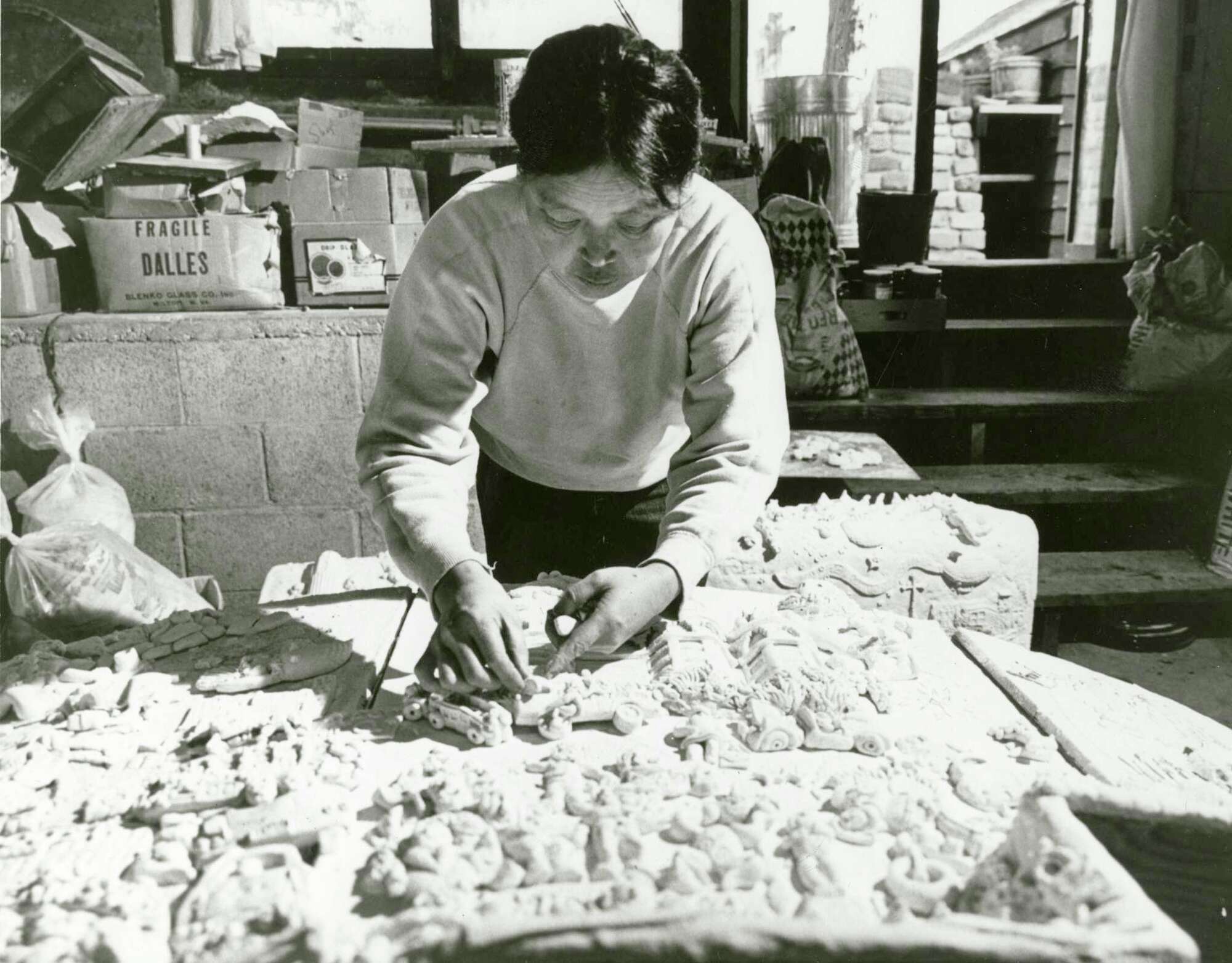 Artist Ruth Asawa arranges figures sculpted in baker's clay for her "San Francisco Fountain."