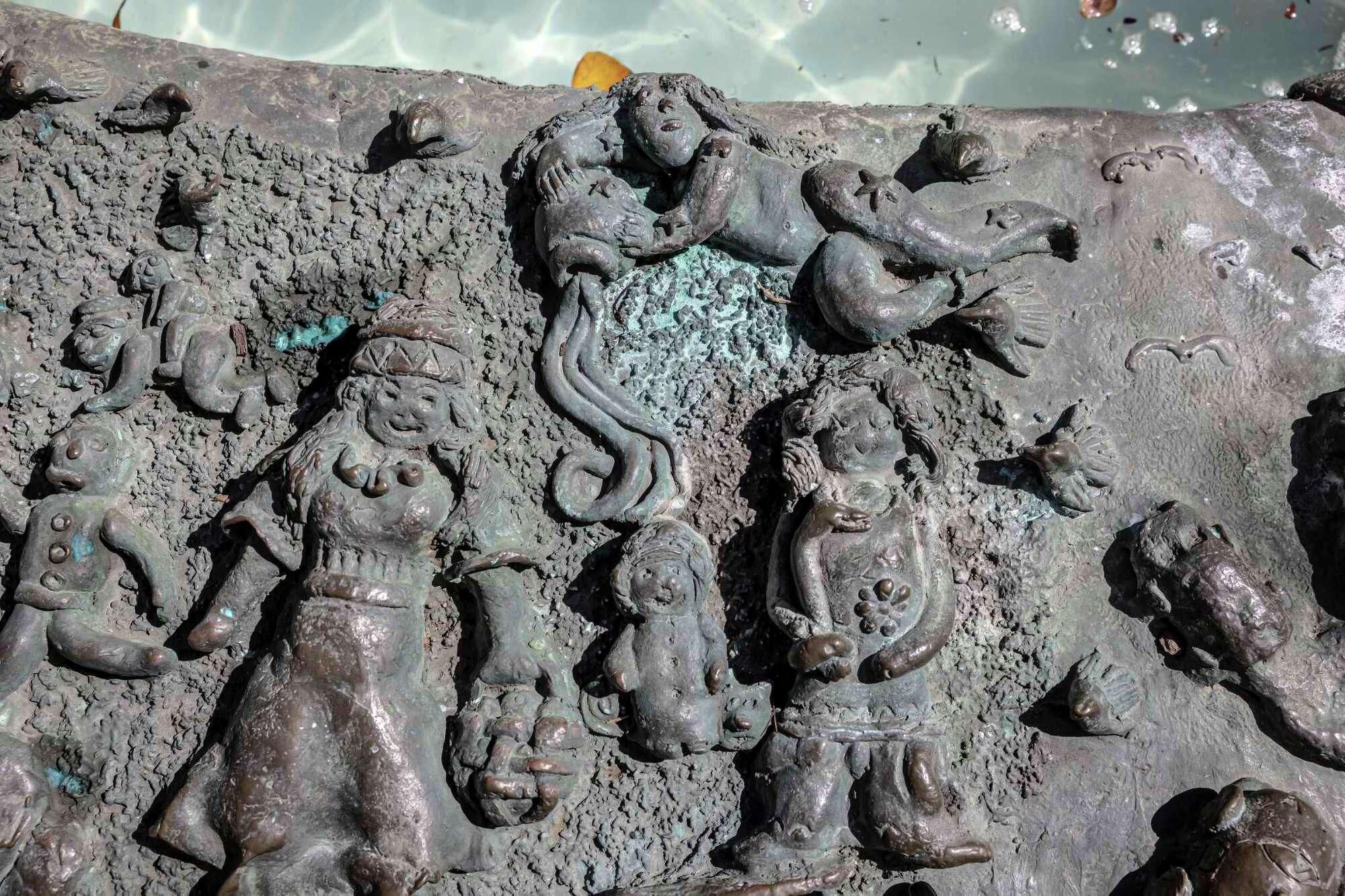 A detail photo of Ruth Asawa's "San Francisco Fountain" shows various people with fine-stranded hair created using a garlic press.