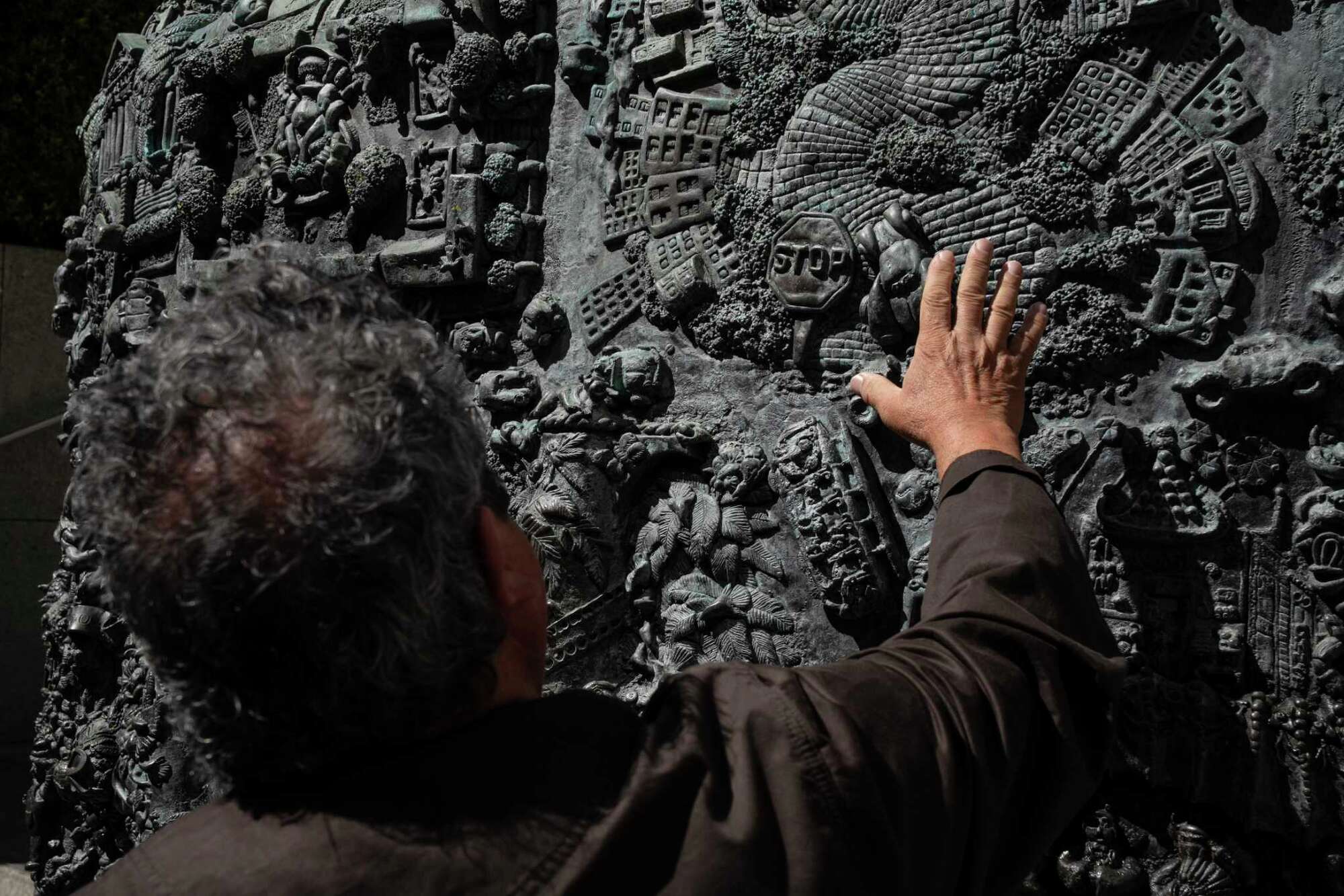 Paul Lanier, Ruth Asawa's son, is seen from the back gesturing at her "San Francisco Fountain."