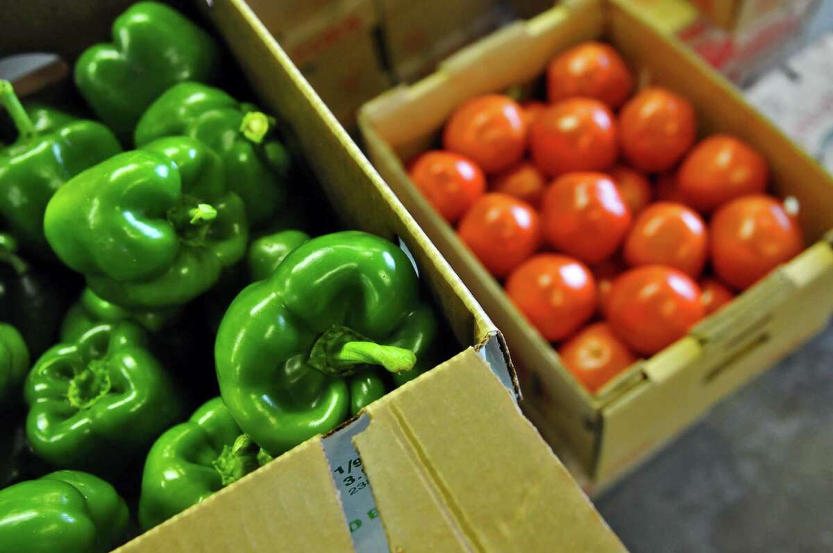 Boxes of fresh-picked green peppers and tomatoes.