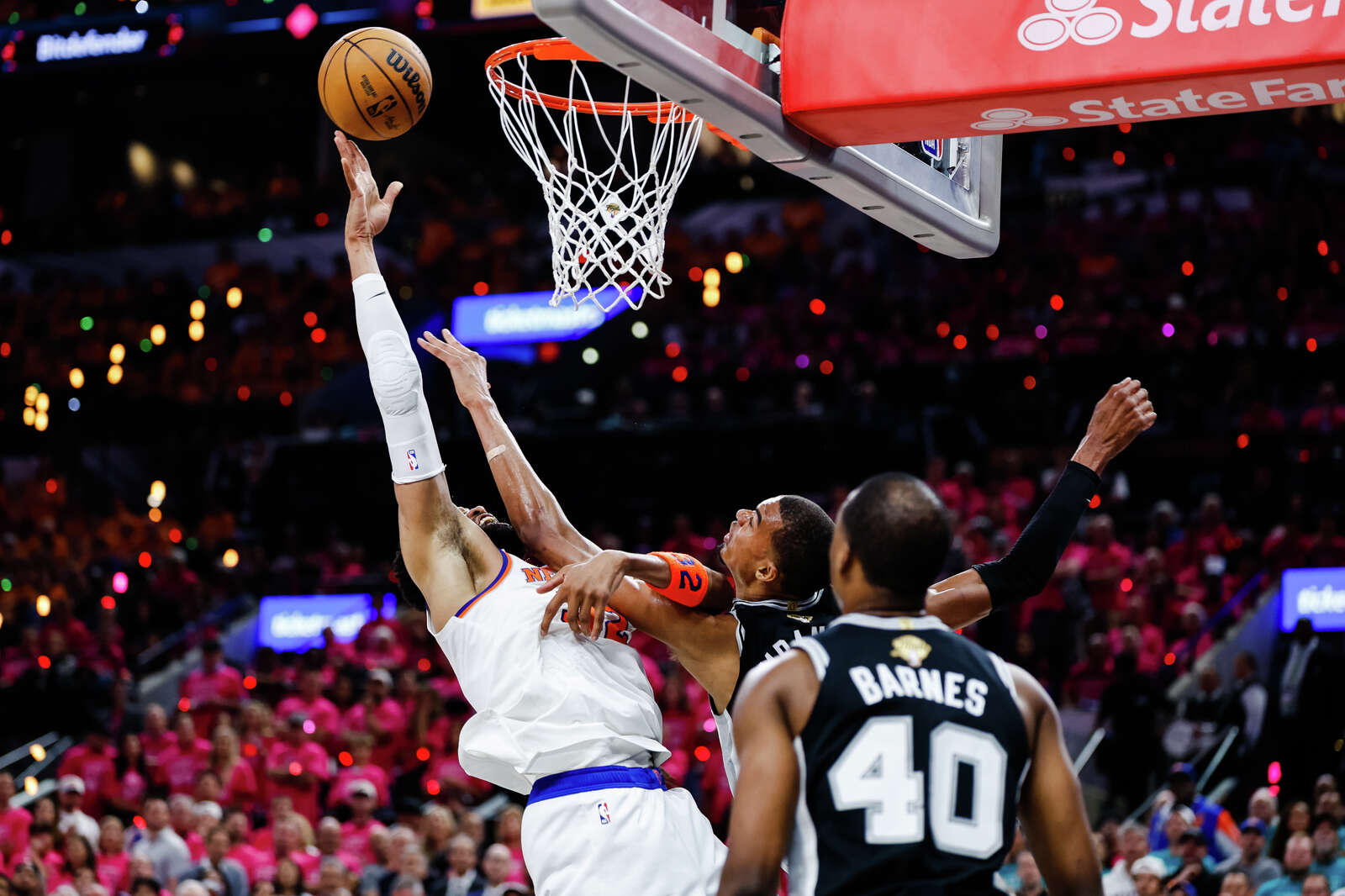 New York Knicks center Karl-Anthony Towns goes up for a shot, hooking the arm of Spurs center Victor Wembanyama, resulting in an offensive foul after being challenged. (Sam Owens/San Antonio Express-News)