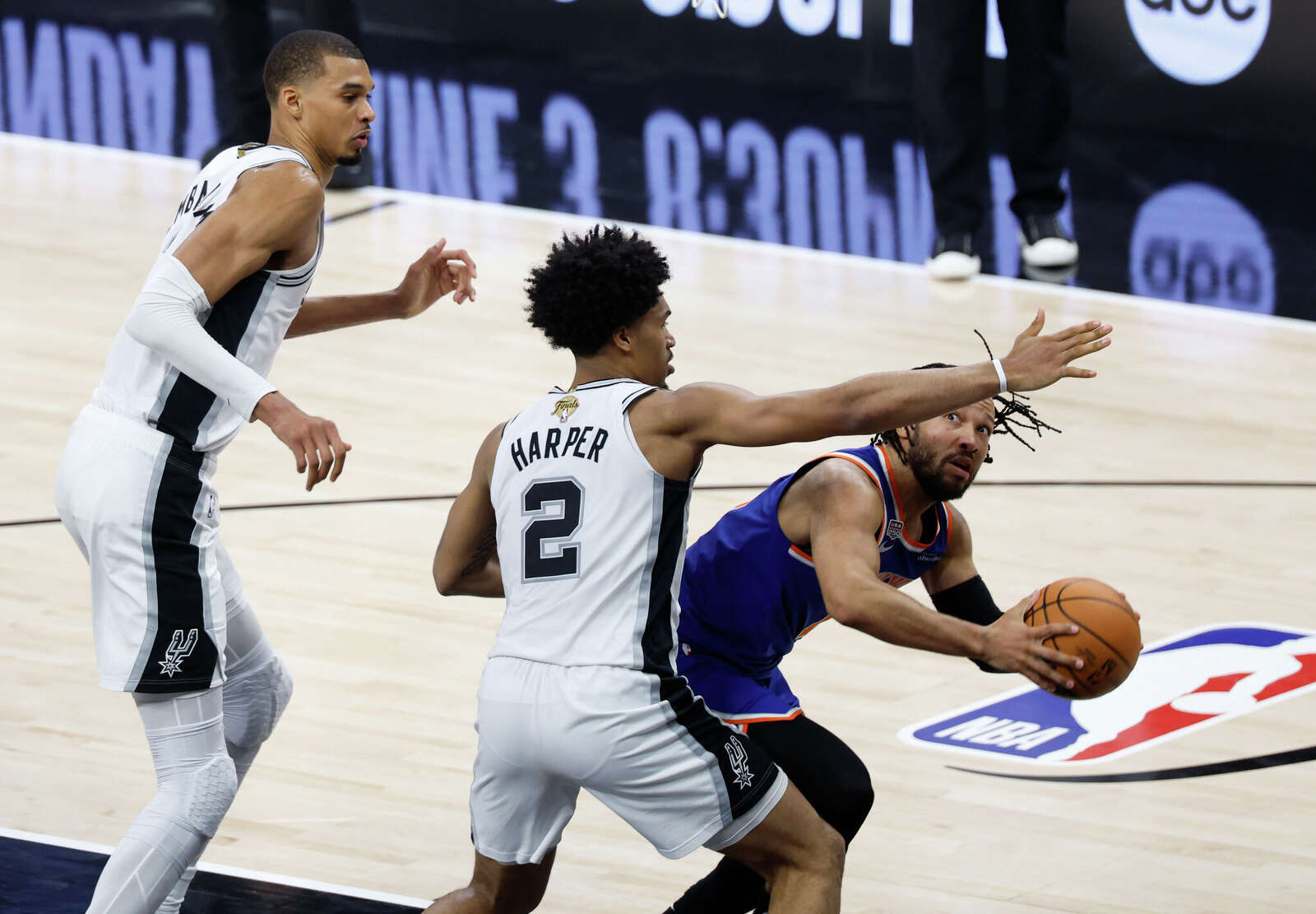 New York Knicks guard Jalen Brunson (11) looks for an open shot past San Antonio Spurs guard Dylan Harper (2) during the second quarter.