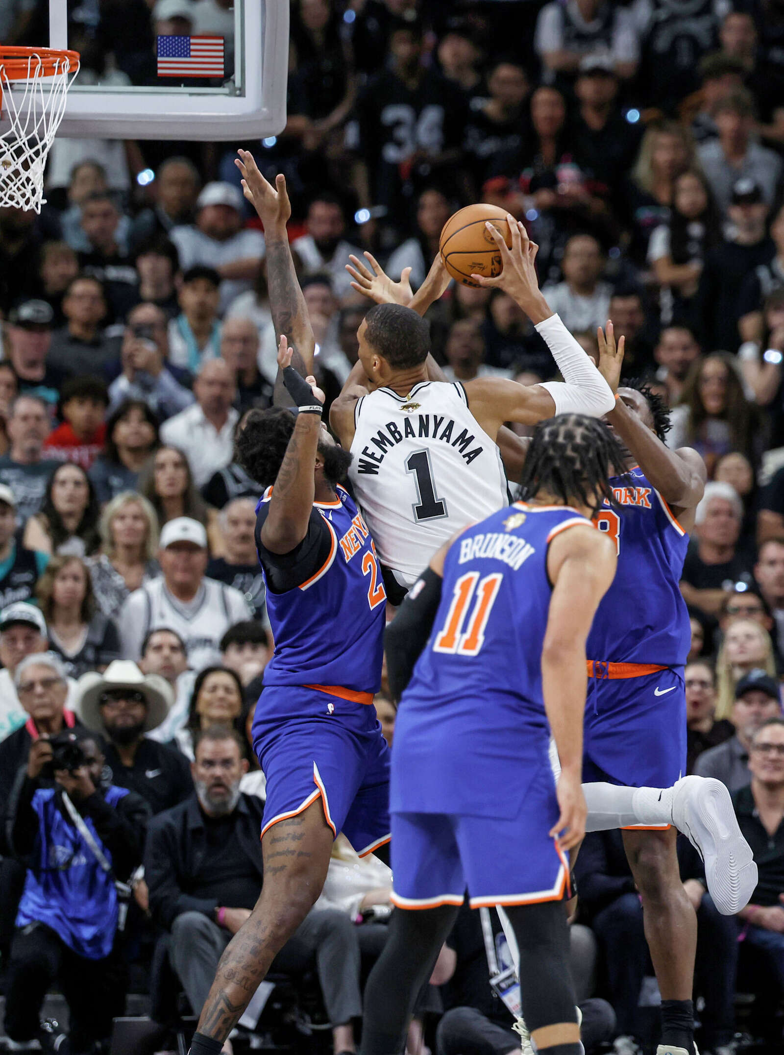 San Antonio Spurs center Victor Wembanyama (1) is surrounded by New York Knicks defenders while trying to take a shot at the basket during the first quarter.