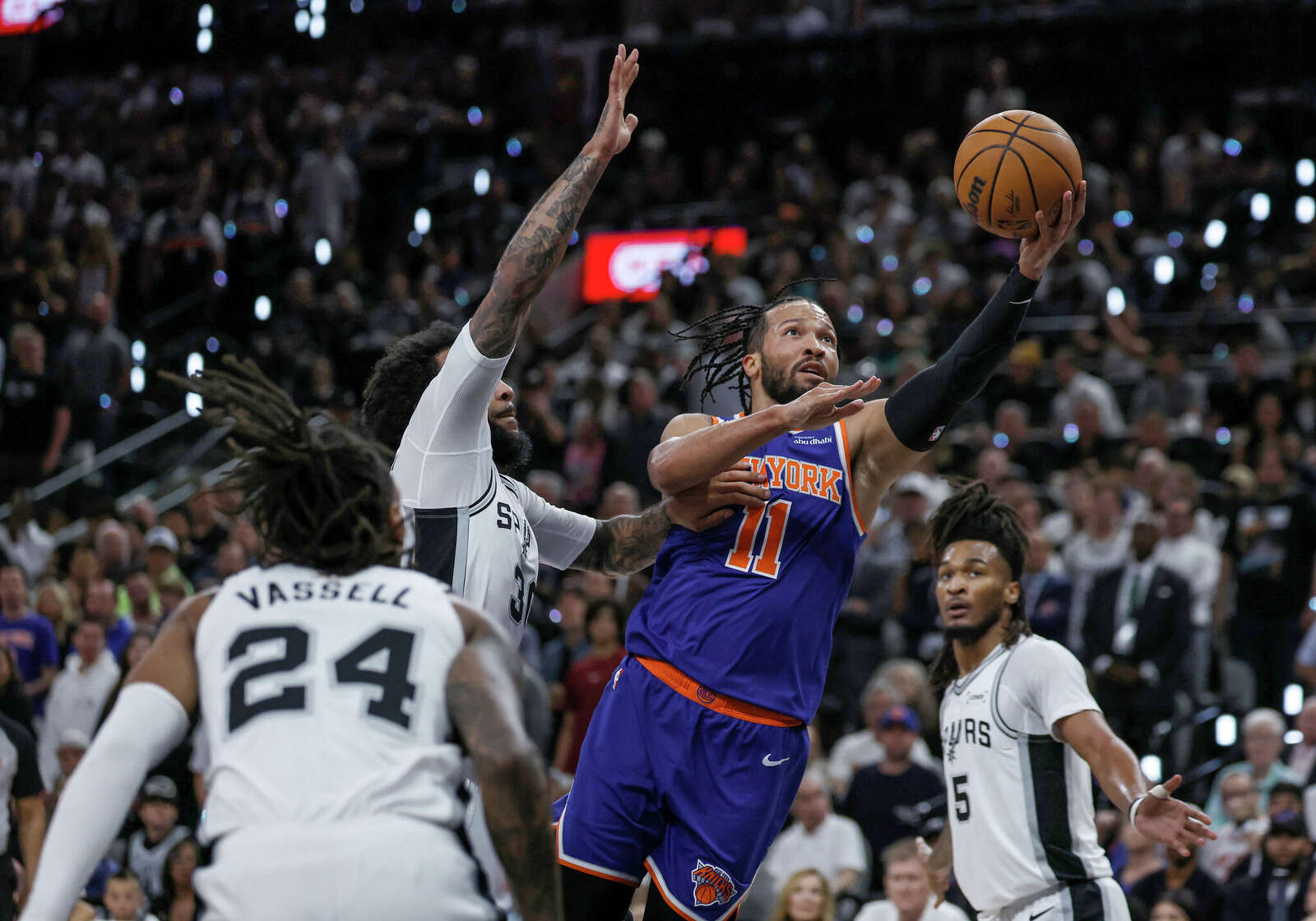 New York Knicks guard Jalen Brunson (11) goes for the layup past San Antonio Spurs forward Julian Champagnie (30) during the first quarter.