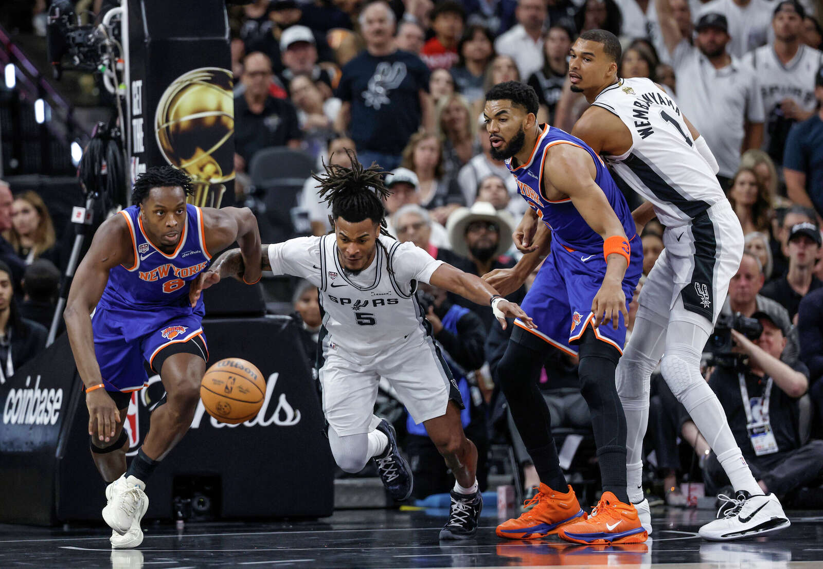 San Antonio Spurs guard Stephon Castle (5) and New York Knicks forward Og Anunoby (8) scramble to grab a loose ball during the first quarter of game 2.