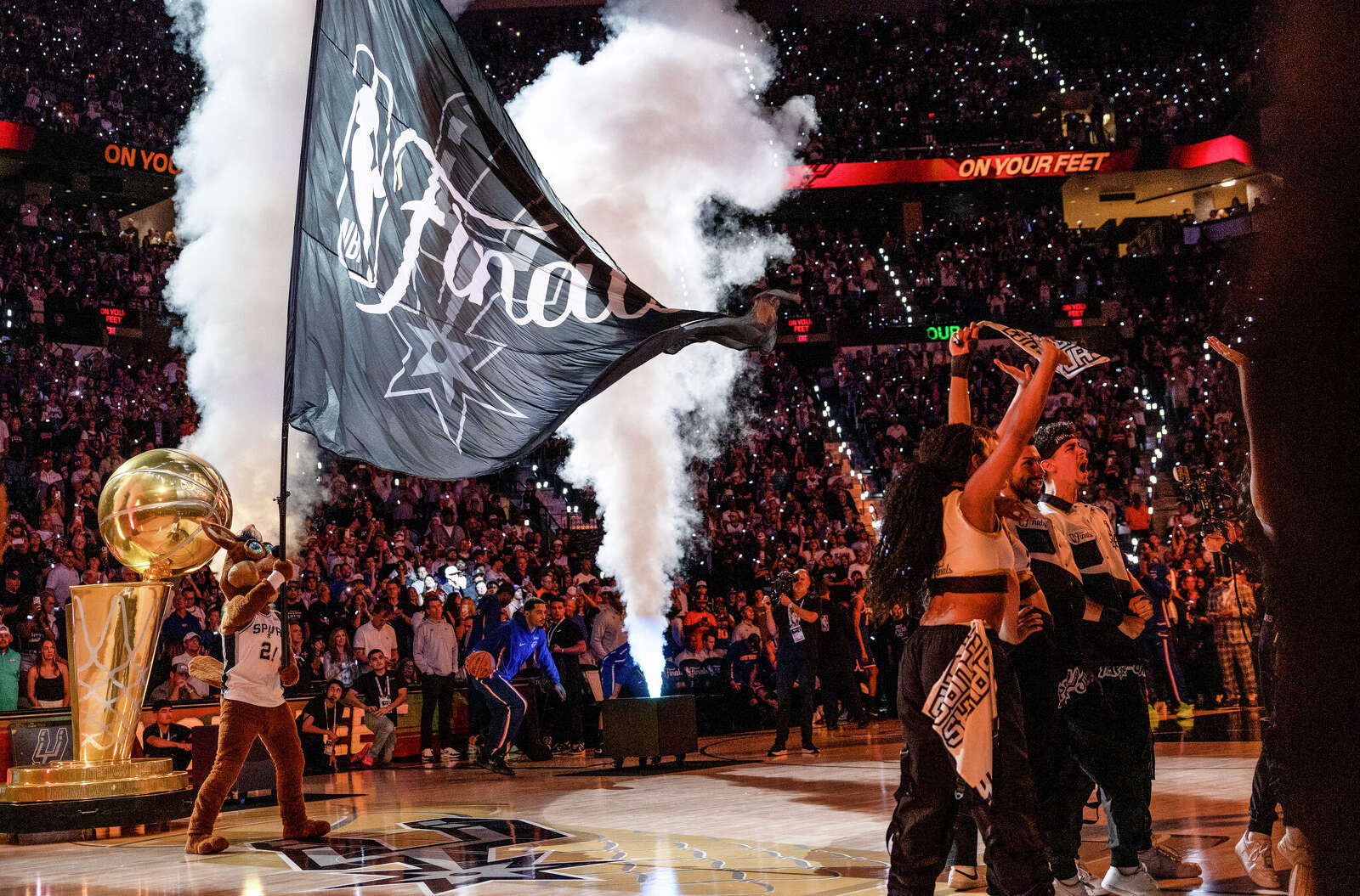 The Spurs Coyote waves the NBA Finals flag during the pre-game 2 show at Frost Bank Center.