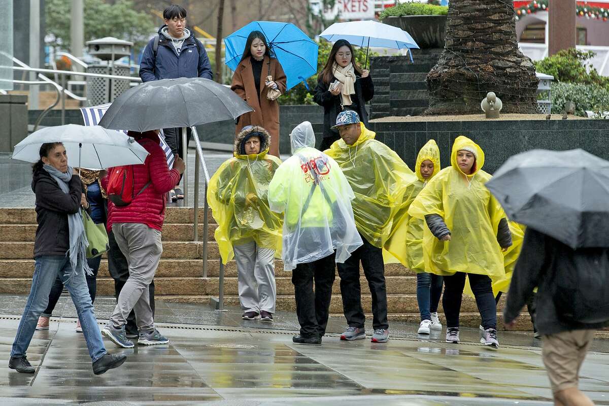 People make their way through the rain at Union Square on Tuesday, Jan. 15, 2019, in San Francisco, Calif.