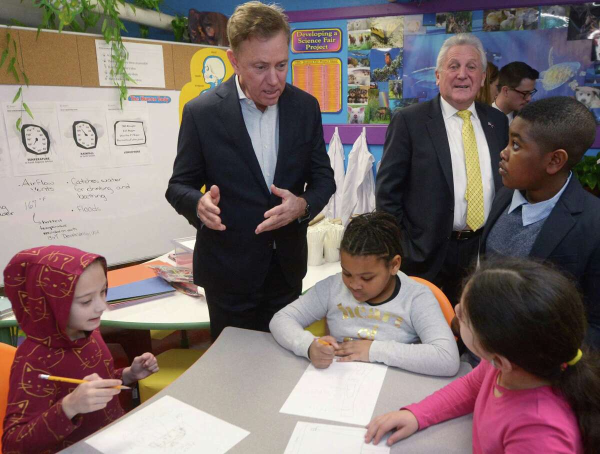 Governor Ned Lamont, left, and Norwalk Mayor Harry Rilling tour a Tracey Elementary School science lab with the help of 5th grader Adrien Danso, right, Wednesday January 16, 2019, prior to a roundtable discussion hosted by the Dalio Foundation at the school in Norwalk, Conn. The event highlighted the forthcoming release of a report from The Aspen Institute National Commission on Social, Emotional, and Academic Development titled, From a Nation at Risk to a Nation at Hope, which outlines steps officials should take to improve public education in the United States.